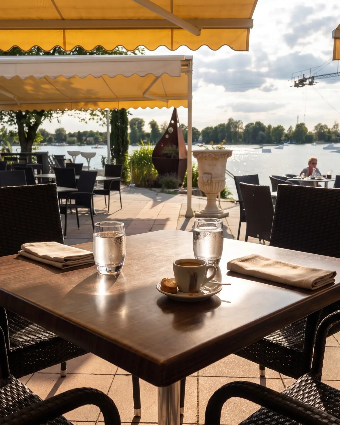 Terrasse am Friedberger Baggersee mit Gästen und Seeblick.