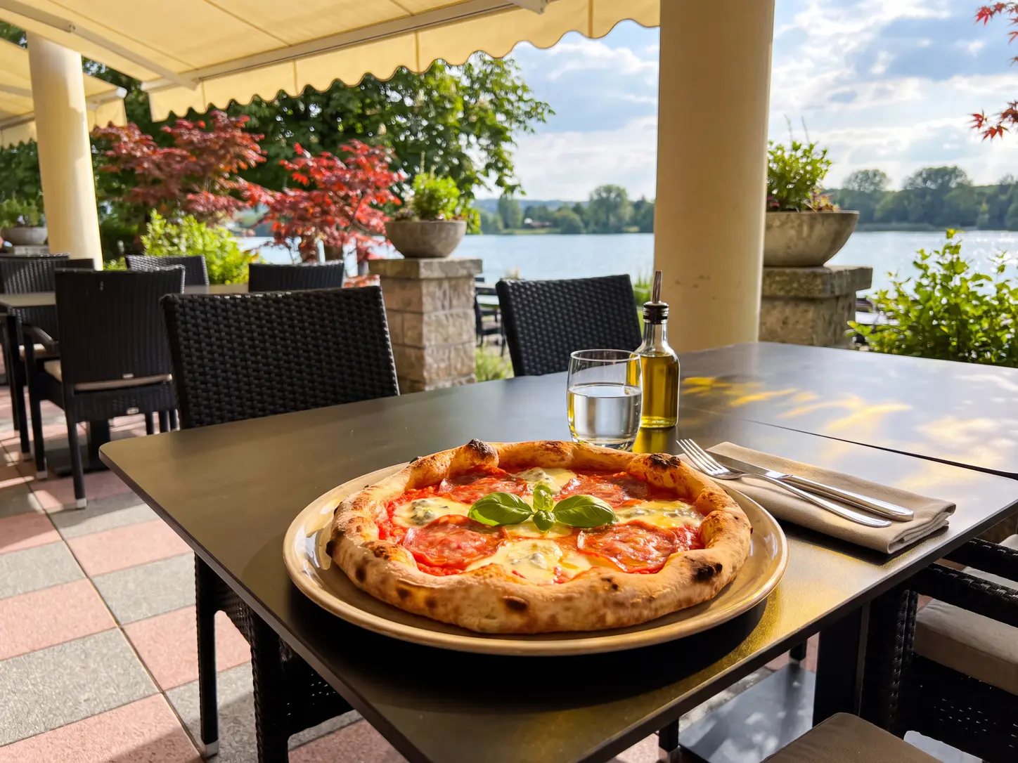 Pizza auf einem Terrassentisch am See.